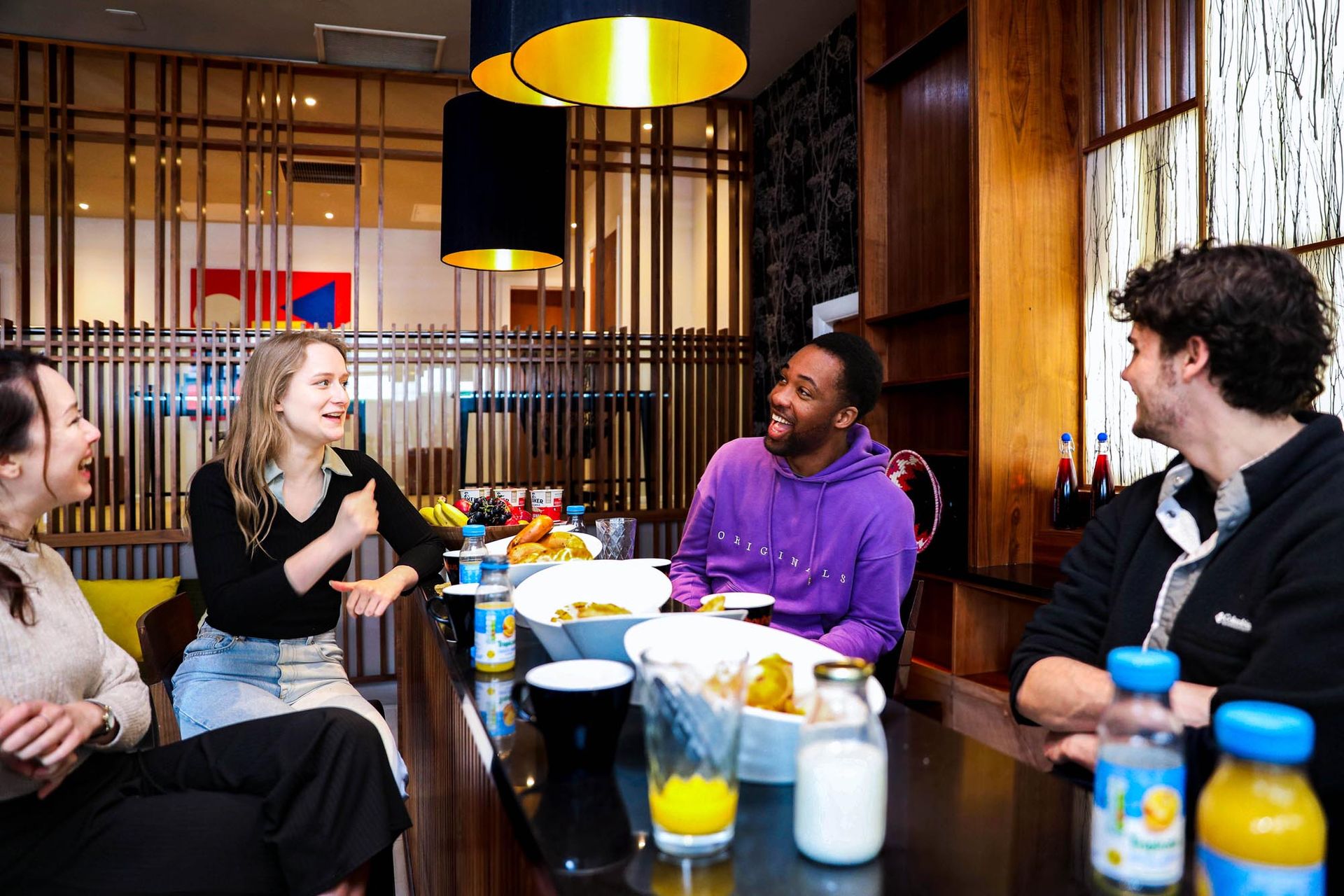 A group of students socialising over food and drink in their student accommodation lobby area