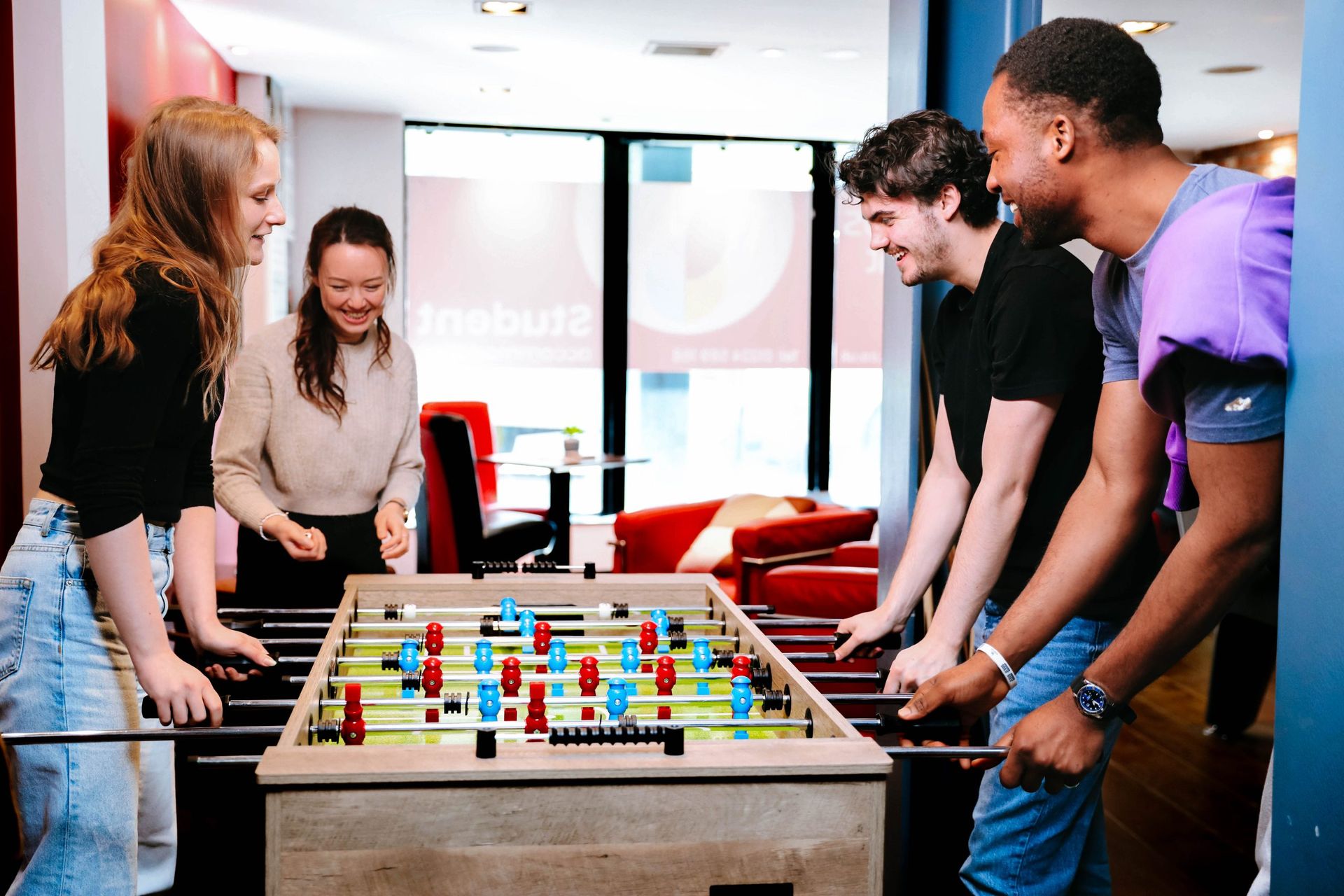 A group of students playing table footballin the communal area of Langstane Place student accommodation