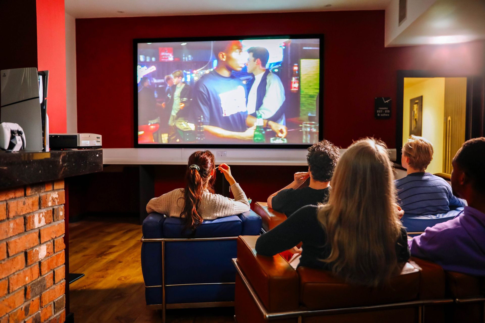 Students watching a movie on a projector screen in a communal area of the langstane place student accommodation